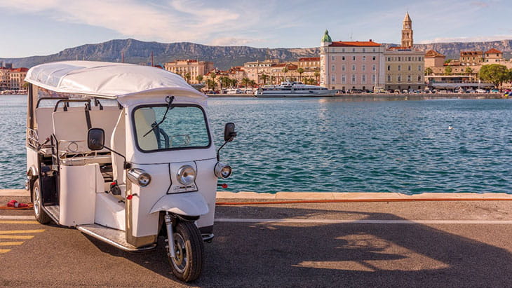 A tuk tuk sitting in front of the harbour in Split, Croatia